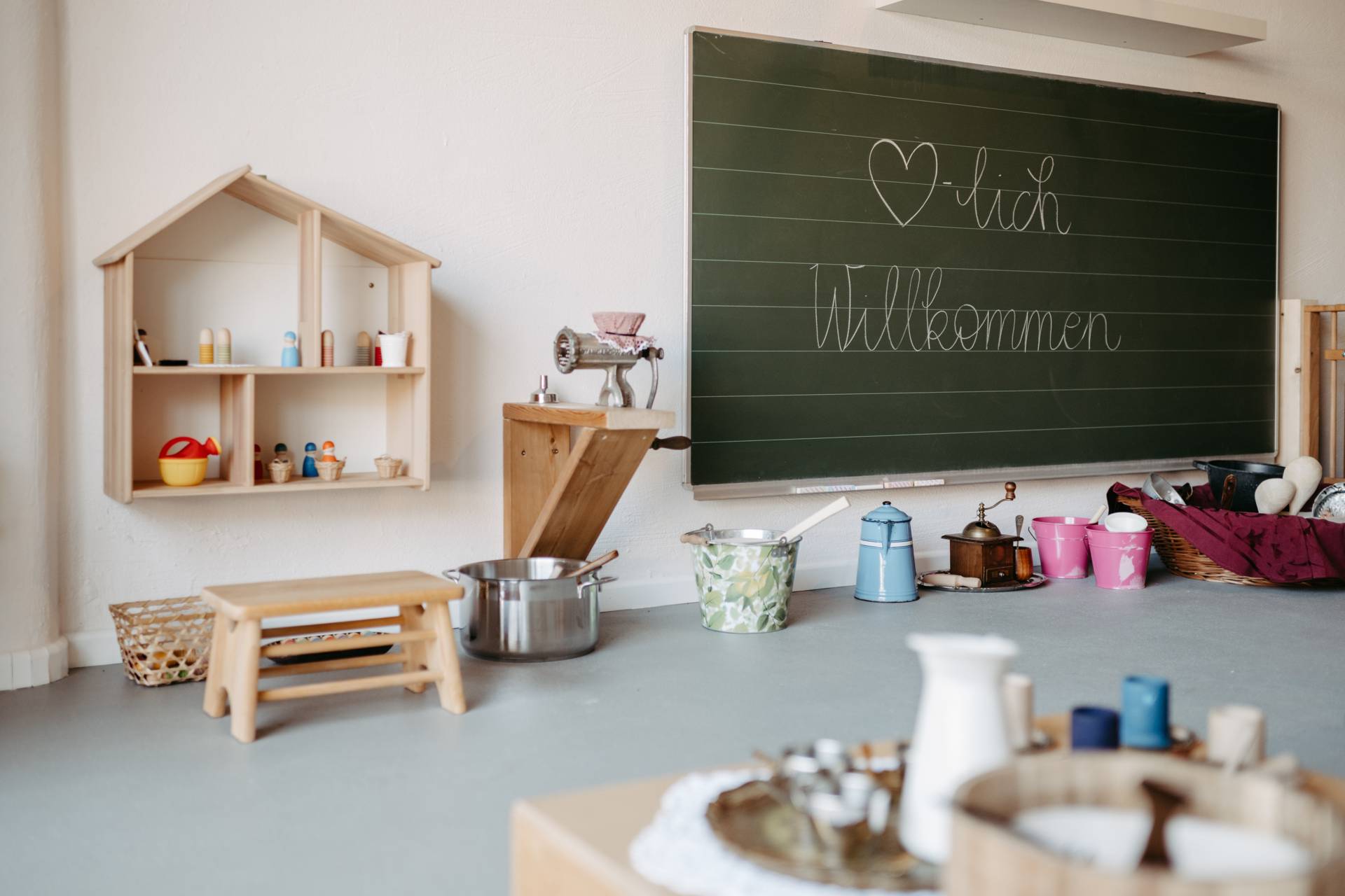 Kinderhände spielen im SandSpielRaum des IM MITEINANDER mit hellem Sand und Holzwerkzeug